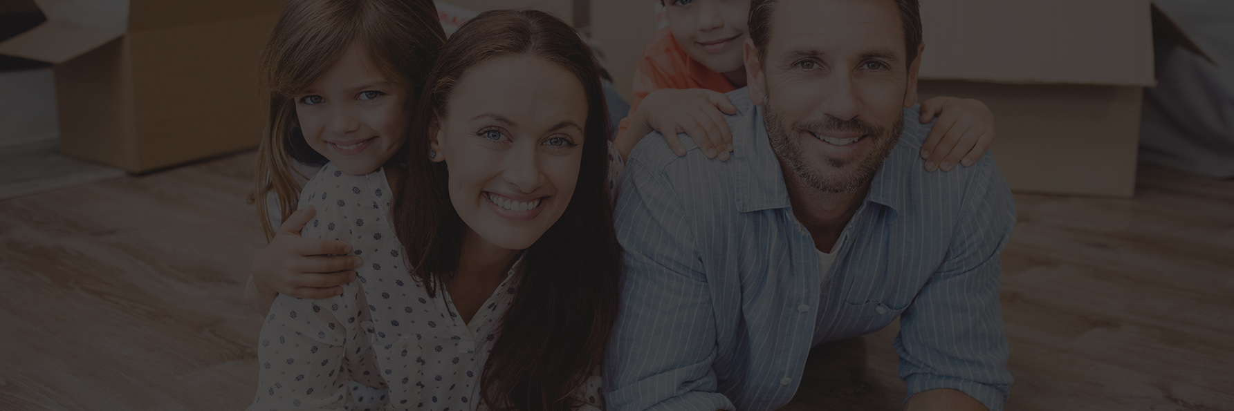 Portrait of happy family lying on hardwood floor at home